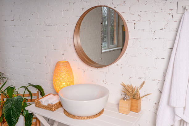 istock Large round mirror above the sink in a stylish light bathroom interior. 1312644083