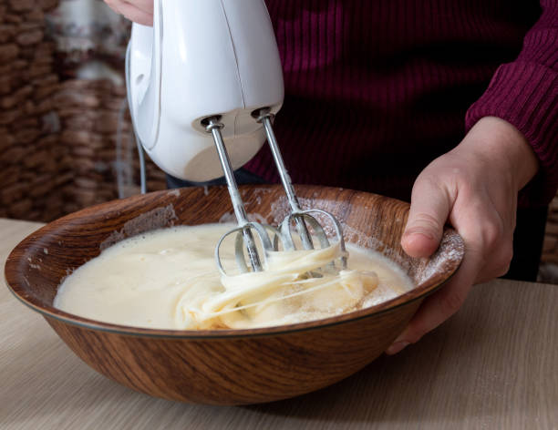 Mix the dough in a bowl with an electric mixer. Selective focus. stock photo