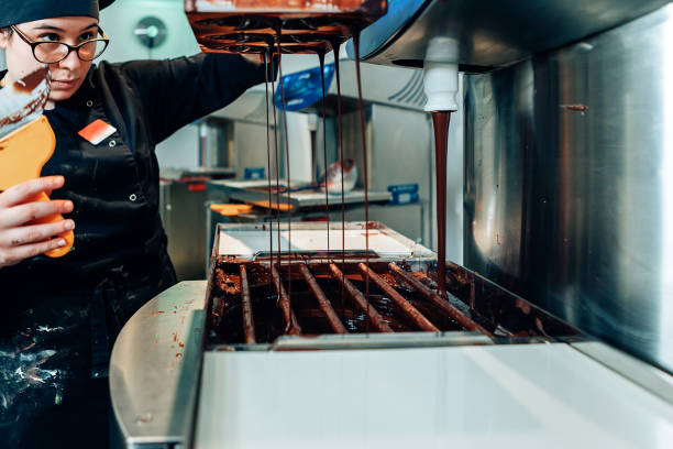 istock professional female chocolatier working at the confectionery workshop with a machine. Chocolate production, technology, processing ingredients. 1312644284