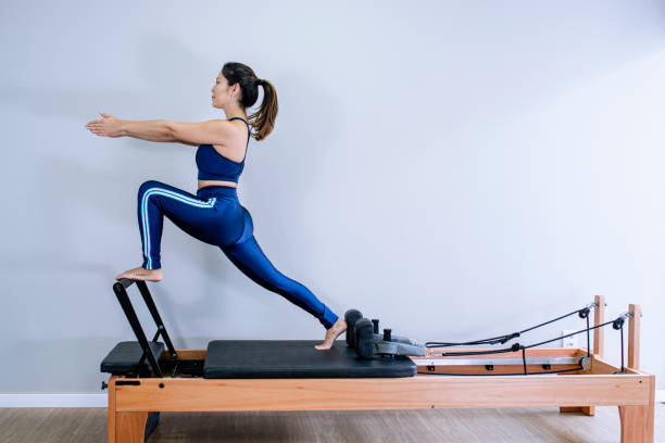 istock Young girl doing pilates exercises with a reformer bed. 1312646815