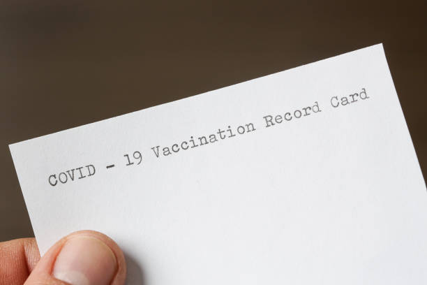 istock Man holding blank COVID-19 vaccination record card, close up image 1312647376