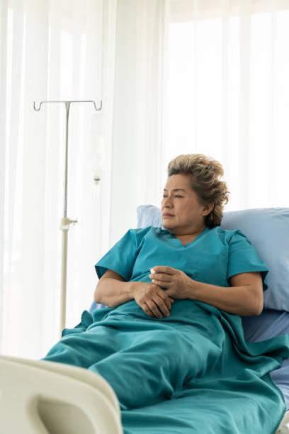 istock Senior patients that need treatment being alone in a patient's bed with sad emotions. 1312648671