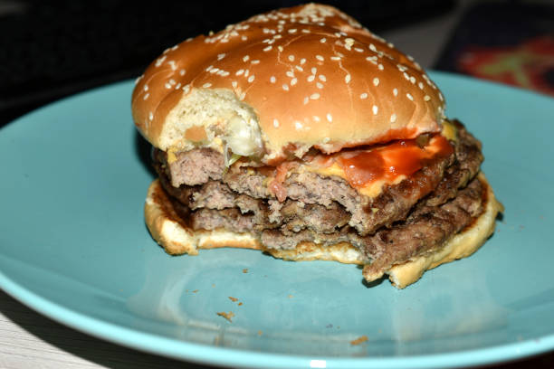 istock Triple meat delicious burger on a blue plate 1312648828