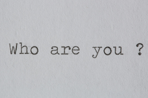 Who are you text on white paper typed on a vintage typewriter