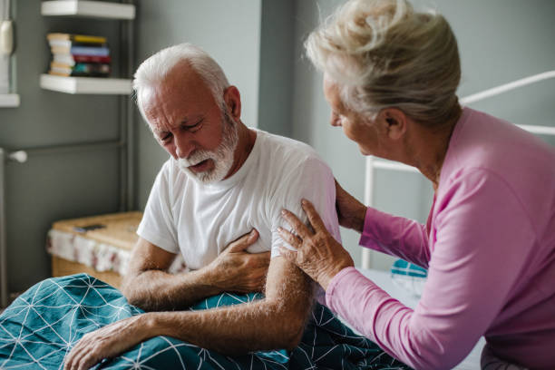 Senior man suffering from chest pain in bed Senior man suffering from a heart attack at home chronic illness stock pictures, royalty-free photos & images