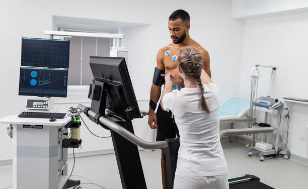 Interpretation Of The Electrocardiogram Of Young Athletes Athlete does a cardiac stress test in a medical study, monitored by the female doctor. stress test stock pictures, royalty-free photos & images