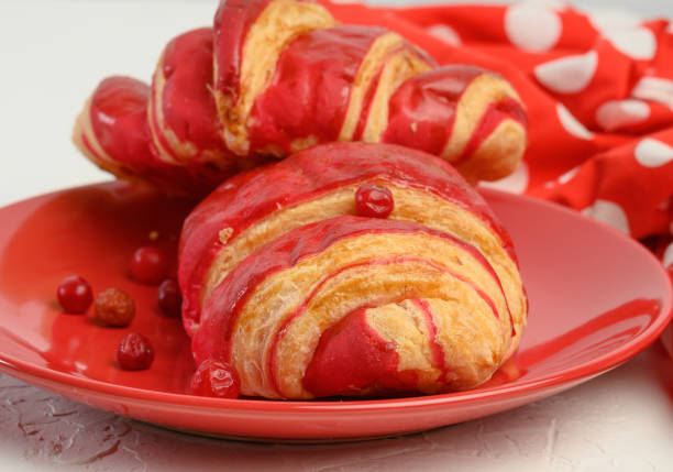 istock baked croissant with cherry glaze on a red ceramic plate 1312650503