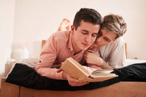 istock Homosexual people reading book on the bed 1312650583