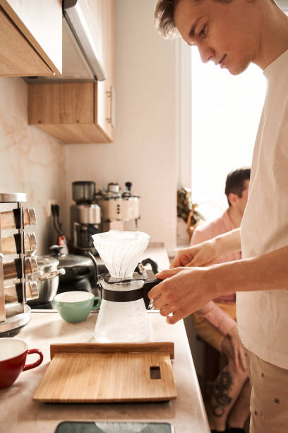istock Man preparing coffee while his boyfriend sitting at the background 1312651751