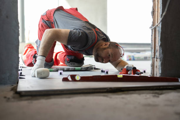 istock Professional builder measuring and leveling the tiled floor 1312654805
