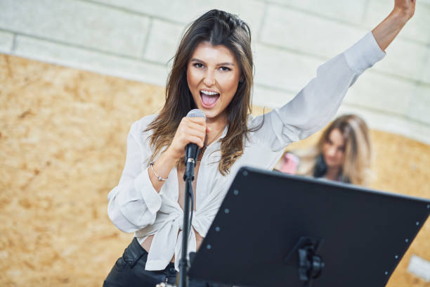 istock Caucasian woman singing into microphone in studio 1312656377