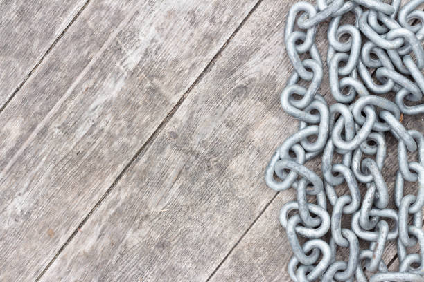 Border of silver steel metal chain links on rustic barn board wood with copy space