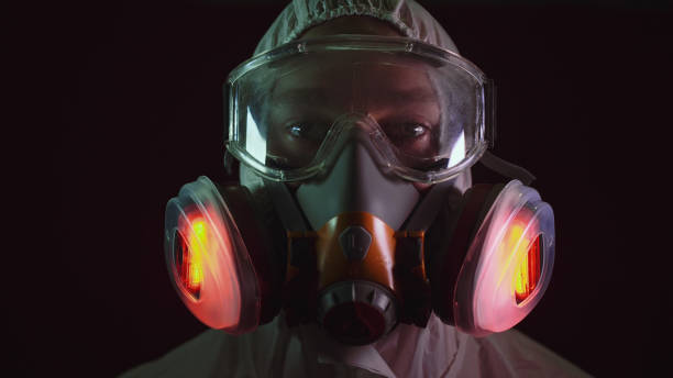 Man in protective costume suit, gas protect medical spray paint mask. Doctor in respirator. Concept health virus coronavirus epidemic. stock photo