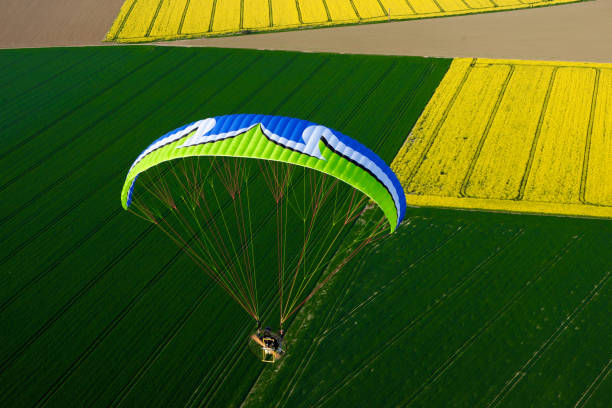 istock Colorful motorized paraglider flying freely over fields in spring 1312661802