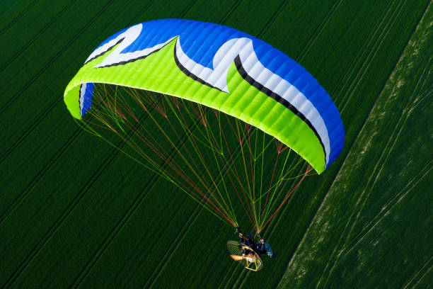 istock Colorful motorized paraglider flying freely over fields in spring 1312662004