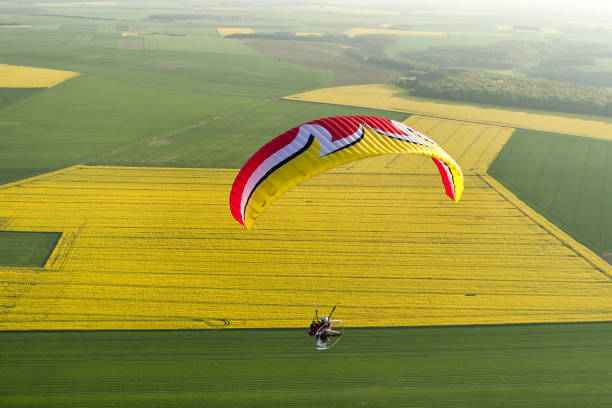 istock Aerial view motorized paraglider flying over rapeseed fields in spring. 1312662142