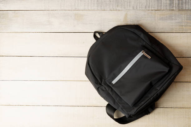 istock black backpack on white wooden background with copy space 1312664409