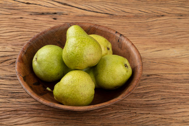 istock Green pears in a bowl over wooden table 1312665229