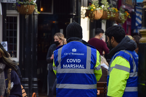 London, United Kingdom - April 14 2021: Covid Marshals in Old Compton Street, Soho. Special Covids Marshals have been deployed in the busy streets of Soho to support the public in observing the social distancing rules.