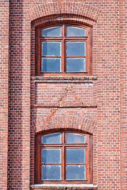 istock Two arched glass windows set in red brick wall 1312666422