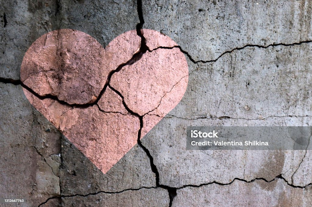 A broken heart. A broken heart. Drawing of a heart on a cracked wall. Broken relationships. Treason and betrayal. Past love. A quarrel. Broken Heart Stock Photo