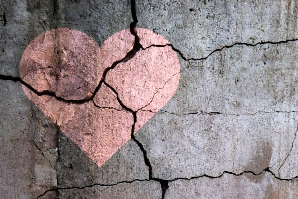 A broken heart. A broken heart. Drawing of a heart on a cracked wall. Broken relationships. Treason and betrayal. Past love. A quarrel. breaking stock pictures, royalty-free photos & images