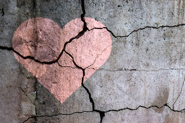 A broken heart. A broken heart. Drawing of a heart on a cracked wall. Broken relationships. Treason and betrayal. Past love. A quarrel. bust stock pictures, royalty-free photos & images