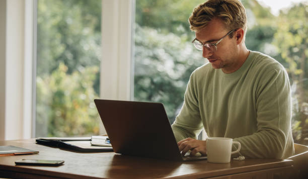 istock Young man working on laptop indoors 1312667928