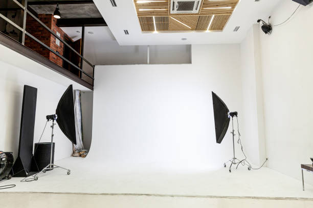 istock Empty photo studio with lighting equipment. Photographer workplace interior with professional tool set gear. Flash light white background scenes ready for studio shooting. Modern photographer studio 1312668899