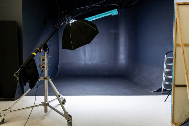 istock Empty photo studio with lighting equipment. Photographer workplace interior with professional tool set gear. Flash light black background scenes ready for studio shooting. Modern photographer studio 1312668903