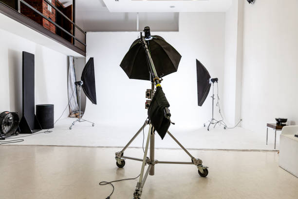 istock Empty photo studio with lighting equipment. Photographer workplace interior with professional tool set gear. Flash light white background scenes ready for studio shooting. Modern photographer studio 1312668914