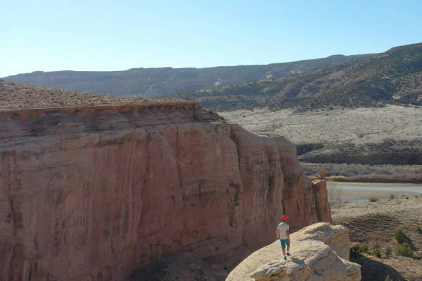 Aerial view of mountain biker relaxing on cliff in the morning He looks off to distant scene of desert environment surrounding Colorado River top view on people walking and cyclists riding stock pictures, royalty-free photos & images