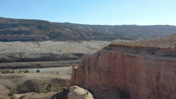 Aerial view of mountain biker relaxing on cliff in the morning He looks off to distant scene of desert environment surrounding Colorado River top view on people walking and cyclists riding stock pictures, royalty-free photos & images
