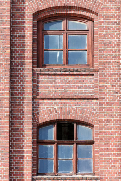 istock Two arched glass windows set in red brick wall 1312671738