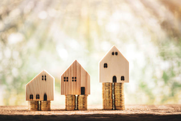 istock House model put on the stack gold coin with growing interest value on sunlight in the public park, Saving money or loan for business investment real estate or buy a new home for a family concept. 1312672075