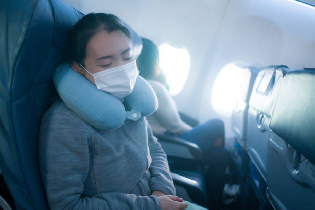 turismo y vuelo en tiempos de covid19 - joven japonesa asiática dulce y cansada con máscara facial sentada en la cabina del avión durmiendo plácidamente durante el vuelo"n - portrait human face chinese ethnicity real people fotografías e imágenes de stock