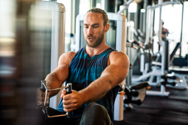 istock Fit man exercising at the gym on a machine 1312673253