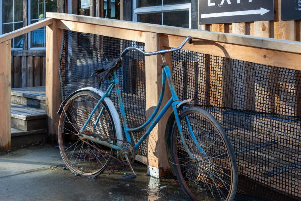 old blue bicycle beside a wooden deck