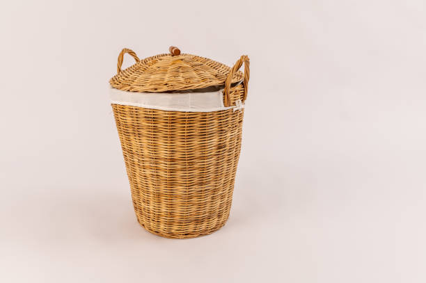 istock Clothes in a laundry wooden basket isolated on white background 1312674411