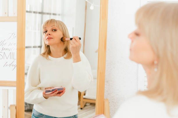 istock woman standing near mirror and doing makeup 1312675092