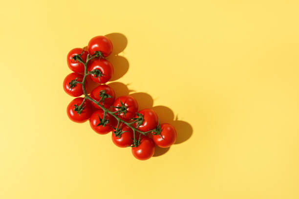 istock Fresh cherry tomatoes with shadow on a yellow background. 1312676666