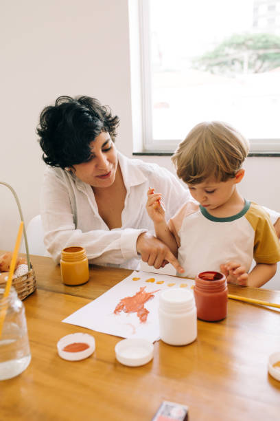 istock Mother teaching her son to paint 1312679196