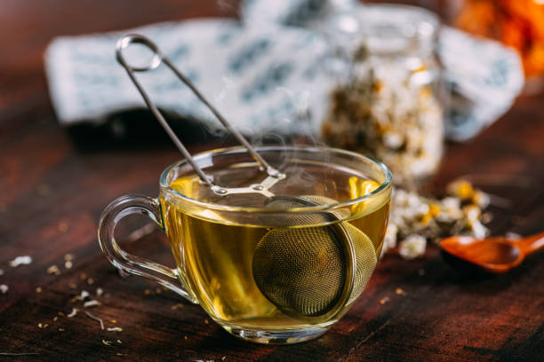 té de manzanilla sobre fondo rústico de madera - te verde fotografías e imágenes de stock