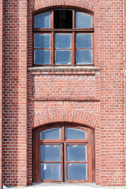 istock Two arched glass windows set in red brick wall 1312682782
