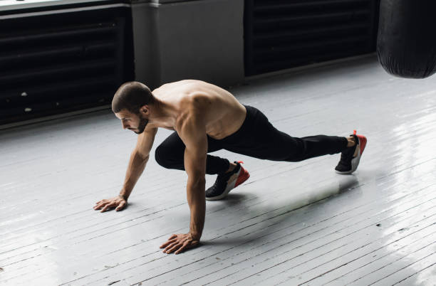 sportsman wearing dark shorts doing push-ups. workout - exercising men push ups muscular build imagens e fotografias de stock