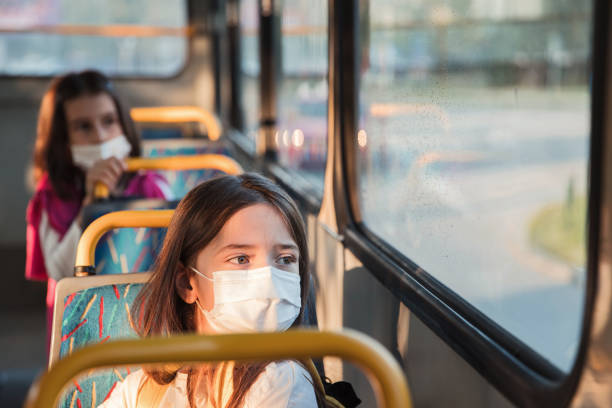 istock Children driving in a school bus and wearing protective masks 1312689969