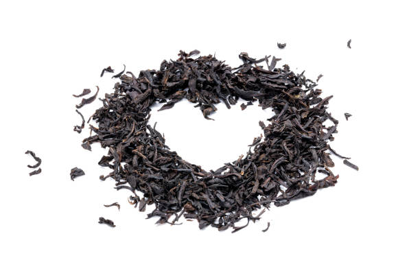 pilha de chá preto seco isolado em fundo branco. folha de chá seca indiana cortada. forma do coração - heart shape isolated isolated on white tea leaves - fotografias e filmes do acervo