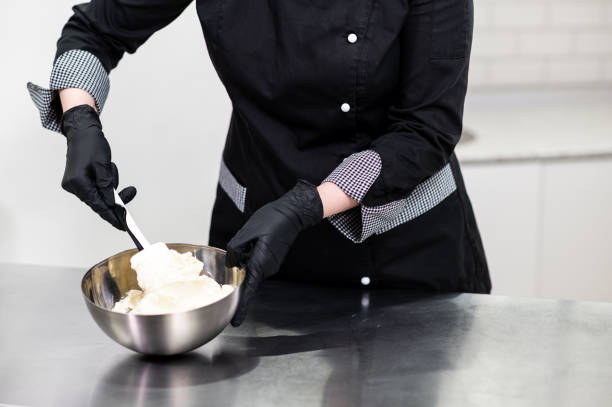 istock woman pastry chef in uniform prepares cake 1312695606