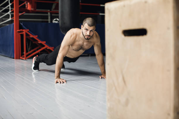 istock Young muscular athlete doing suspension pushups 1312696439