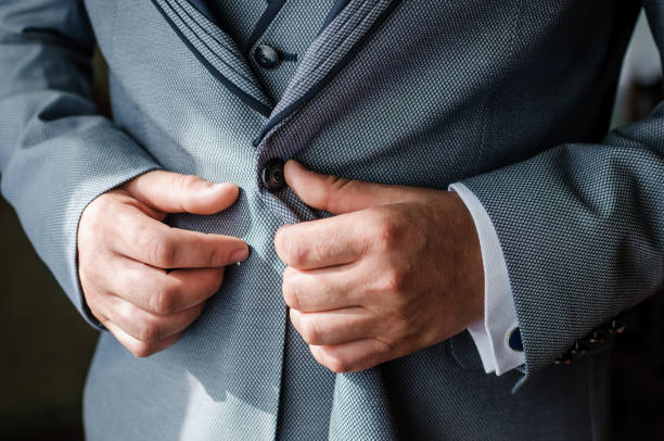 istock The man fasten a button on his jacket. The groom fasten a button on his jacket 1312696515